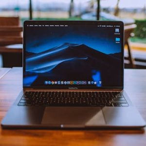 Home A sleek laptop on a wooden table in a cozy indoor setting, perfect for remote work.