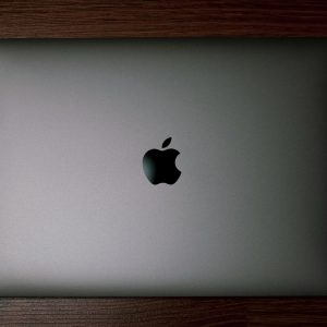 Home Minimalist flatlay of a closed MacBook on a wooden surface, perfect for tech and workspace themes.