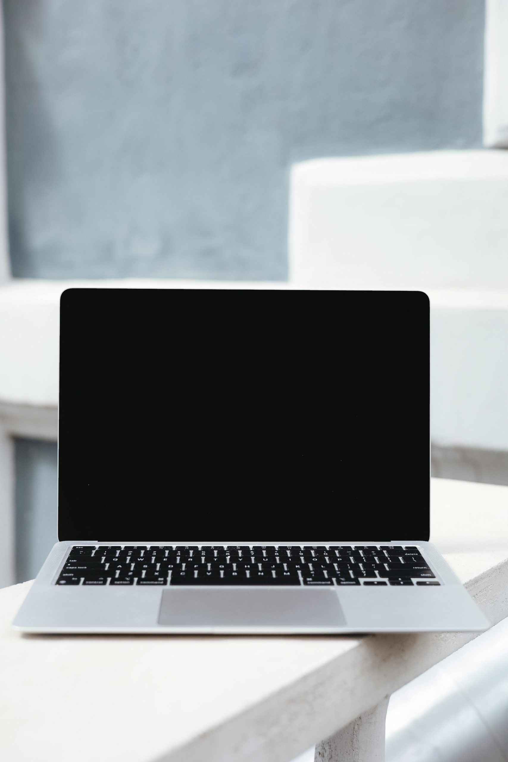 used macbooks Showcase of a sleek laptop with a blank screen against a minimalist modern backdrop.